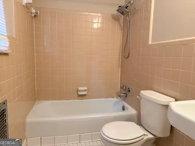 a bathroom with a toilet bathtub and shower