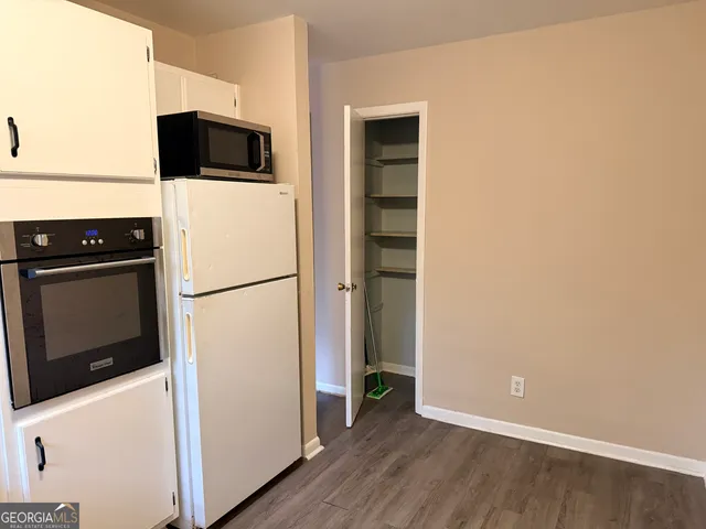 a view of kitchen with wooden floor and electronic appliances