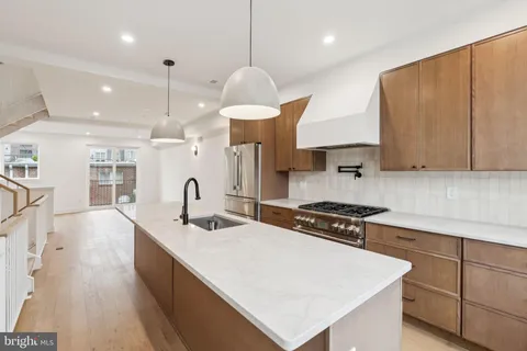 a kitchen with stainless steel appliances a sink a stove a refrigerator and cabinets