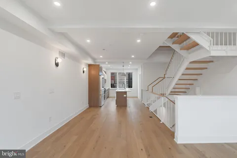 a view of a livingroom with wooden floor and stairs
