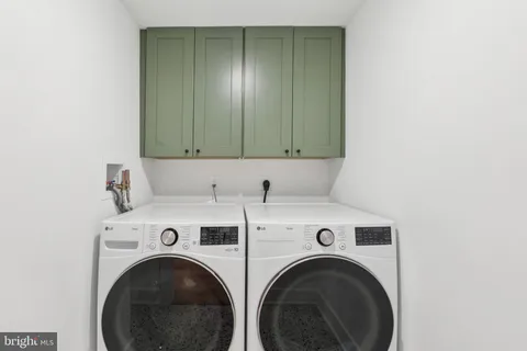 a view of washer and dryer with kitchen in the background