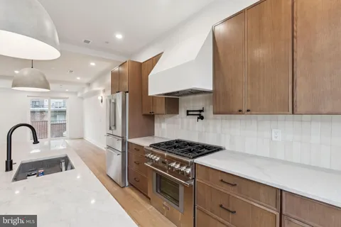a kitchen with stainless steel appliances a stove a sink a refrigerator and cabinets