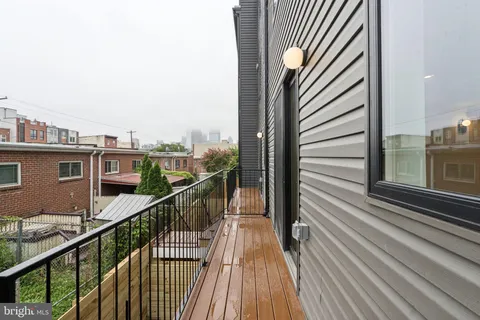 a view of a balcony with wooden floor and fence