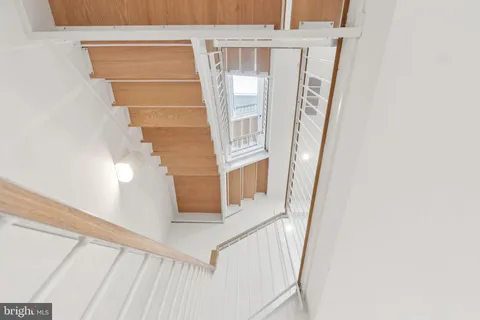 a view of staircase with railing and white walls