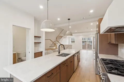a kitchen with stainless steel appliances a sink a stove a refrigerator and cabinets