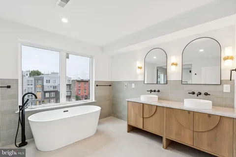 a bathroom with a double vanity sink a mirror and a bathtub