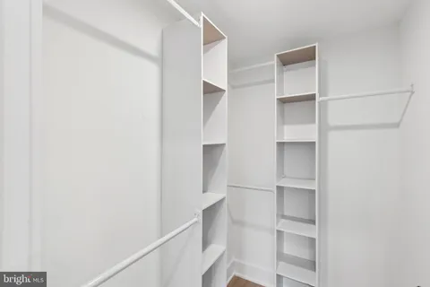 a view of walk in closet with empty racks