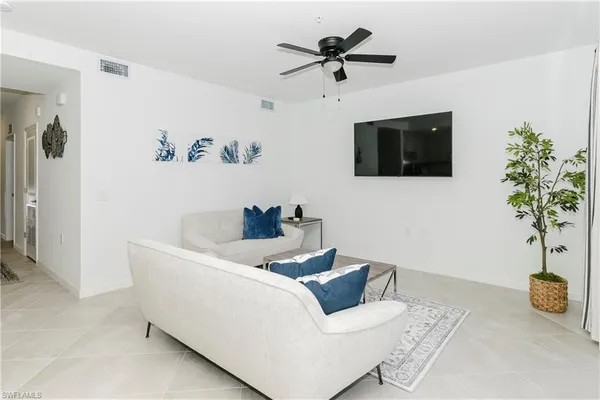 a living room with furniture and a potted plant