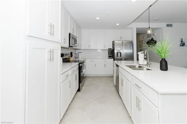 a kitchen with white cabinets and stainless steel appliances