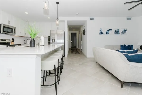 a kitchen with a table chairs refrigerator and microwave