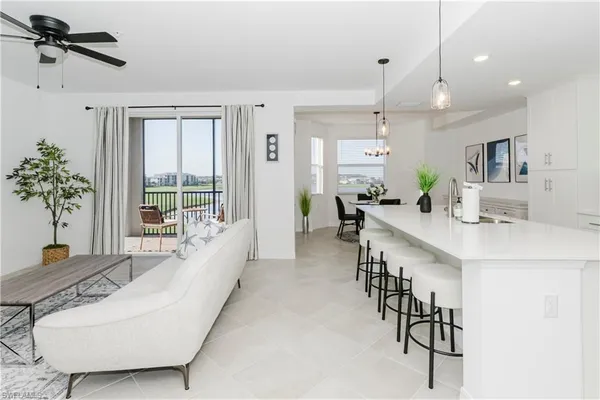a large living room with stainless steel appliances kitchen island granite countertop furniture and a large window