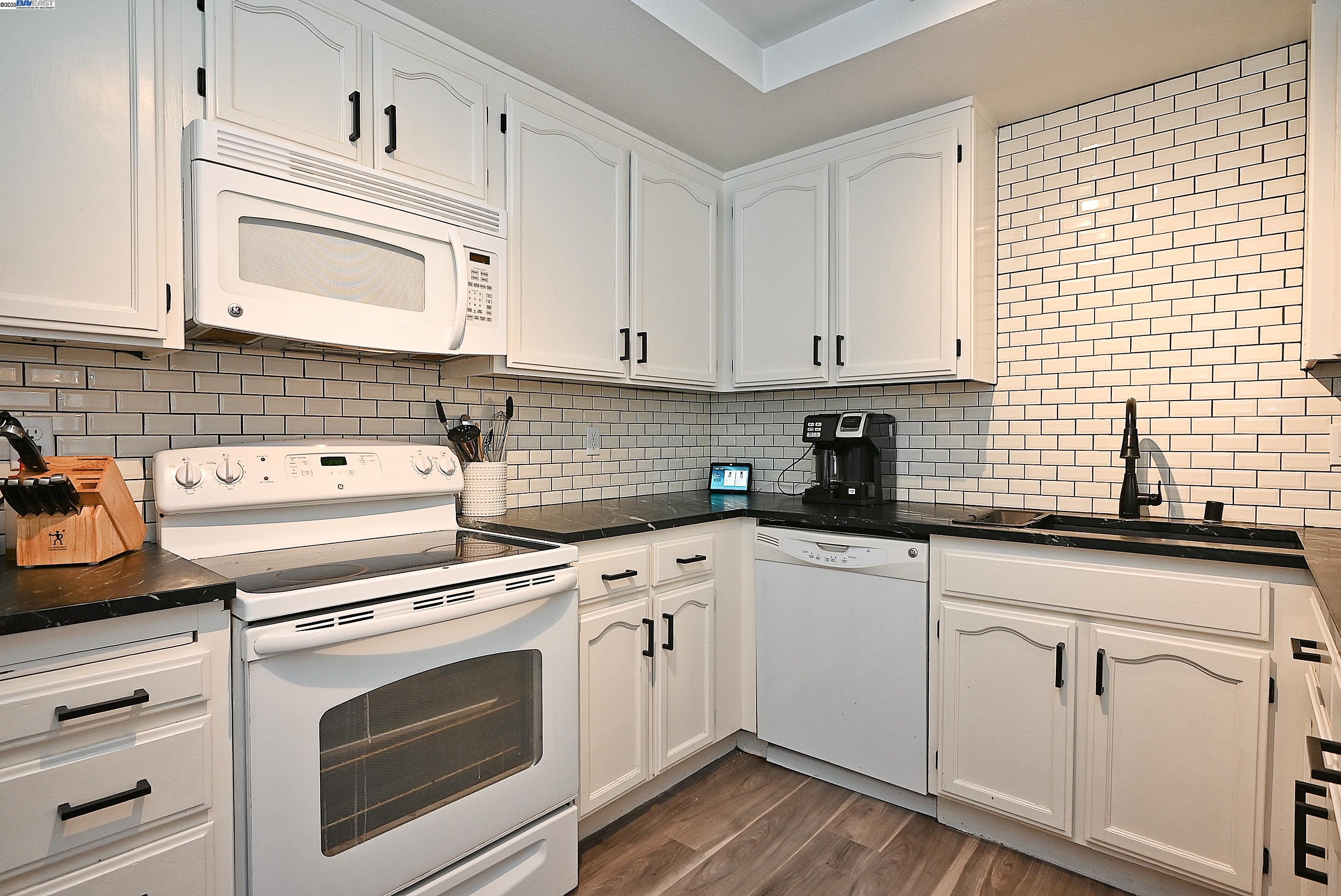 2073 Sand Point Road Discovery Bay, CA 94505 - Photo 24 of 40 a kitchen with white cabinets stainless steel appliances and sink