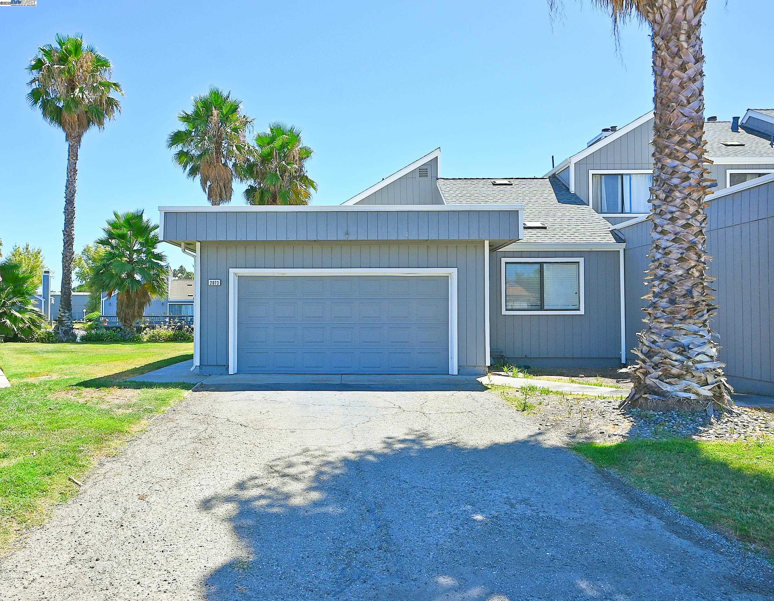 2073 Sand Point Road Discovery Bay, CA 94505 - Photo 7 of 40 a front view of a house with a yard and garage