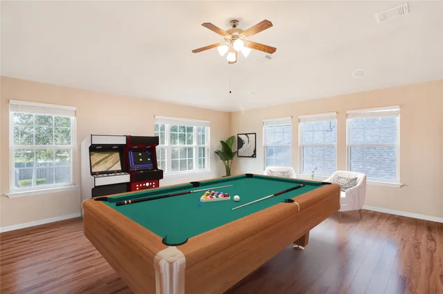 a room with pool table and windows