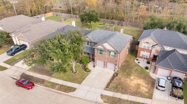 an aerial view of residential houses with outdoor space and parking