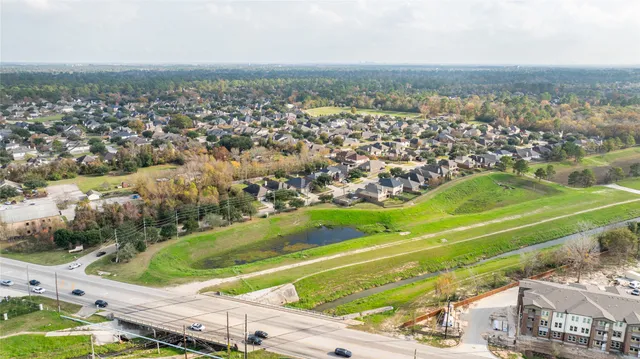 an aerial view of residential houses with outdoor space and trees