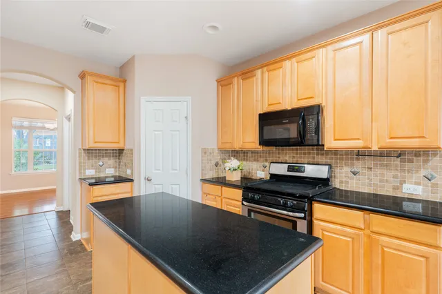 a kitchen with stainless steel appliances a stove sink microwave and cabinets