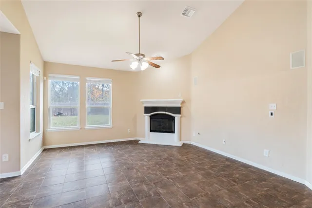 a view of an empty room with a fireplace and a window