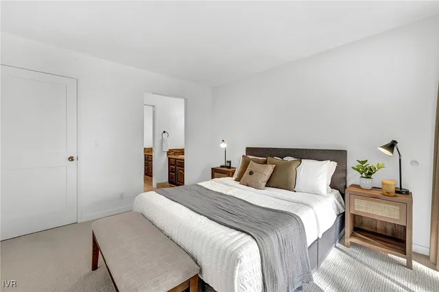 a bed sitting in a bedroom next to a window