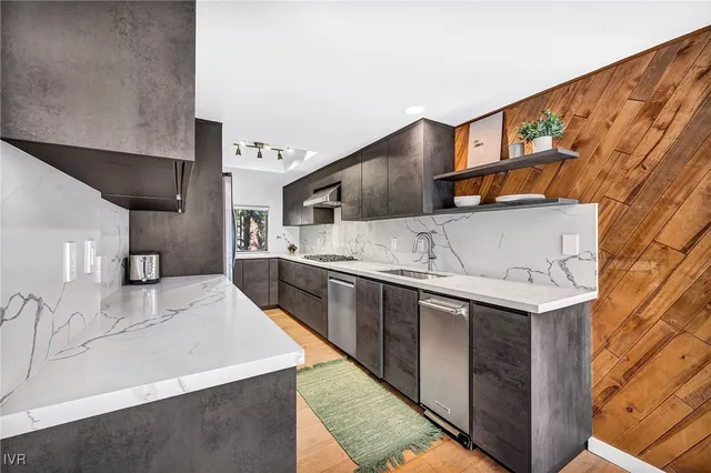a kitchen with stainless steel appliances granite countertop a sink and a stove