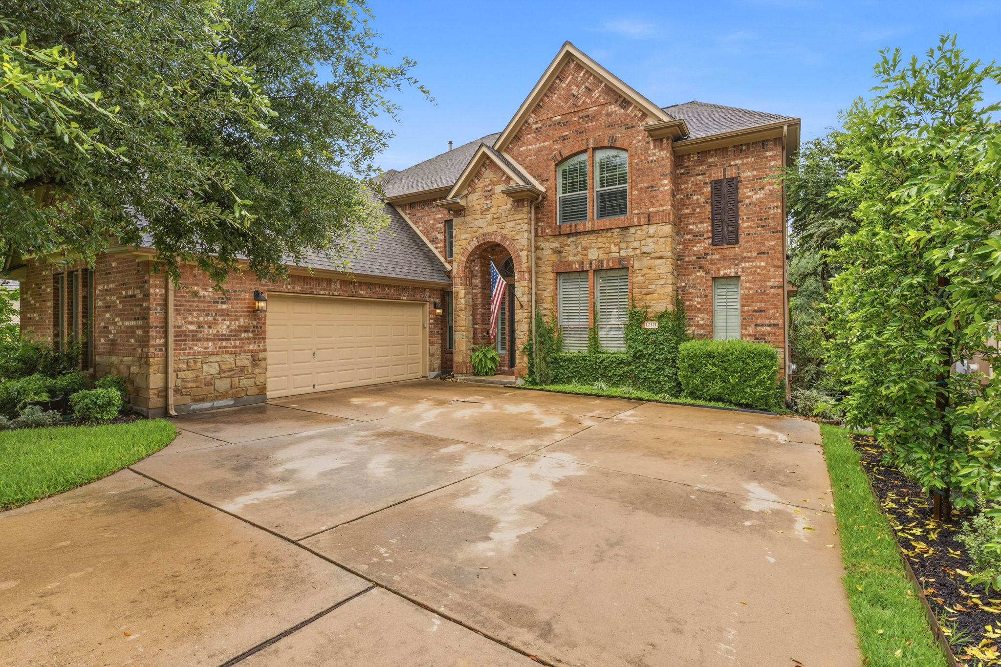 12321 Edenvale Path Austin, TX 78732 - Photo 1 of 36 A classic brick and stone facade welcomes with an arched entry and integrated two-car garage.