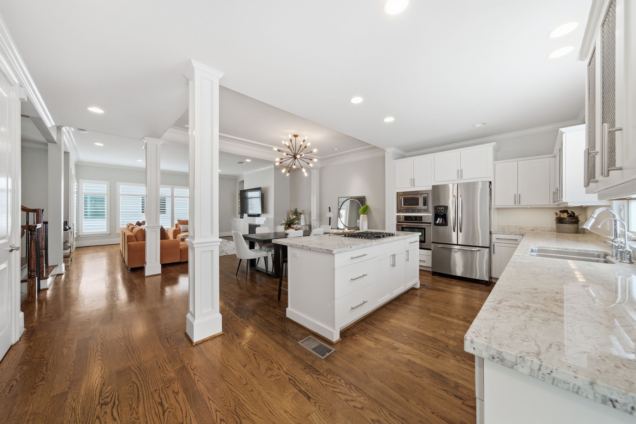 4915 Chenevert Street Houston, TX 77004 - Photo 15 of 41 Expansive chef’s kitchen features an oversized marble-topped island with built-in gas cooktop, generous counter space, and abundant custom cabinetry for organized storage. The open-concept design seamlessly connects to the dining and living areas, creating a welcoming flow ideal for entertaining and everyday living.