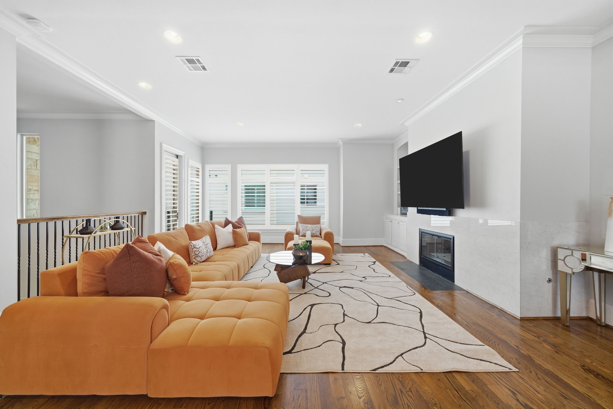 4915 Chenevert Street Houston, TX 77004 - Photo 2 of 41 The spacious living room features hardwood flooring, a contemporary fireplace, and seamless flow to a private balcony. Expansive windows fill the area with natural light, while the open layout is ideal for entertaining or relaxing in modern comfort.