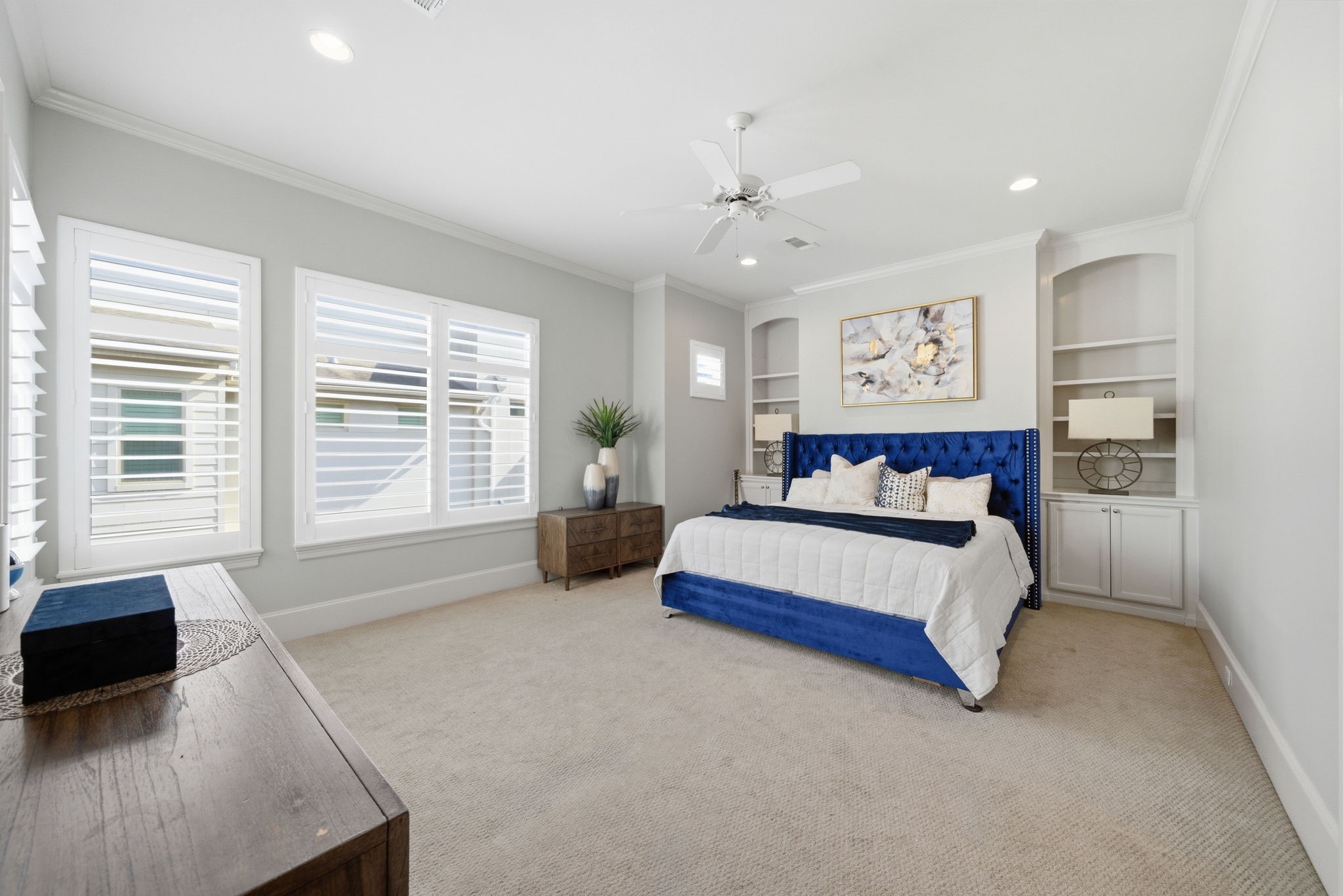 4915 Chenevert Street Houston, TX 77004 - Photo 21 of 41 The expansive primary bedroom features soaring ceilings, an elegant alcove bed wall with custom built-ins, and abundant space for a sitting area or workspace. Enjoy the comfort of plush carpeting, peaceful natural light, private balcony access, and direct entry to a spa-inspired ensuite bath and oversized walk-in closet.