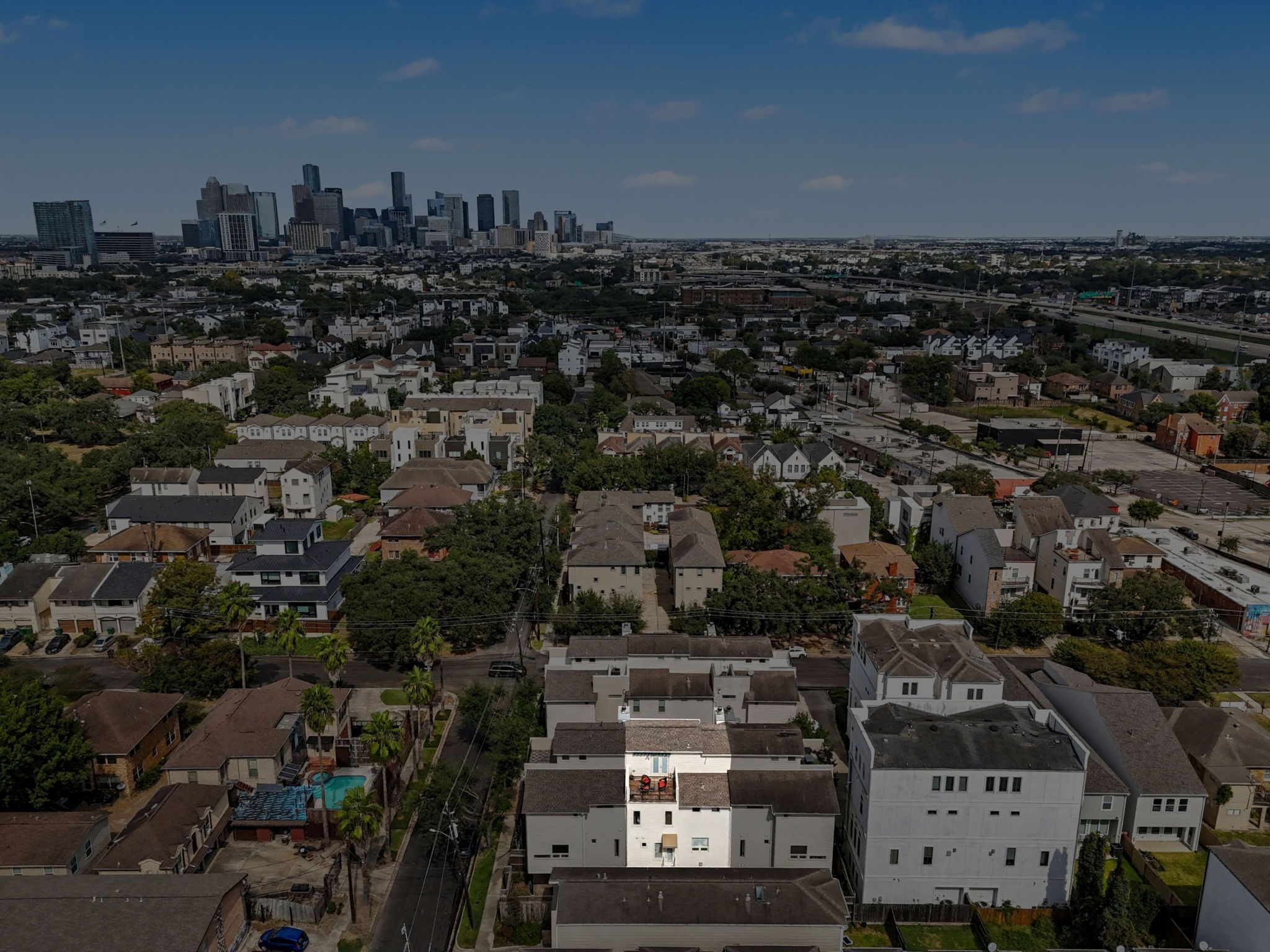 4915 Chenevert Street Houston, TX 77004 - Photo 41 of 41 Expansive primary bedroom features oversized windows with plantation shutters, custom built-in shelving, and tranquil neutral tones. High ceilings and flexible layout offer room for a cozy sitting area or workspace, while soft carpeting creates an inviting retreat with direct access to a spa-inspired ensuite bath and walk-in closet.