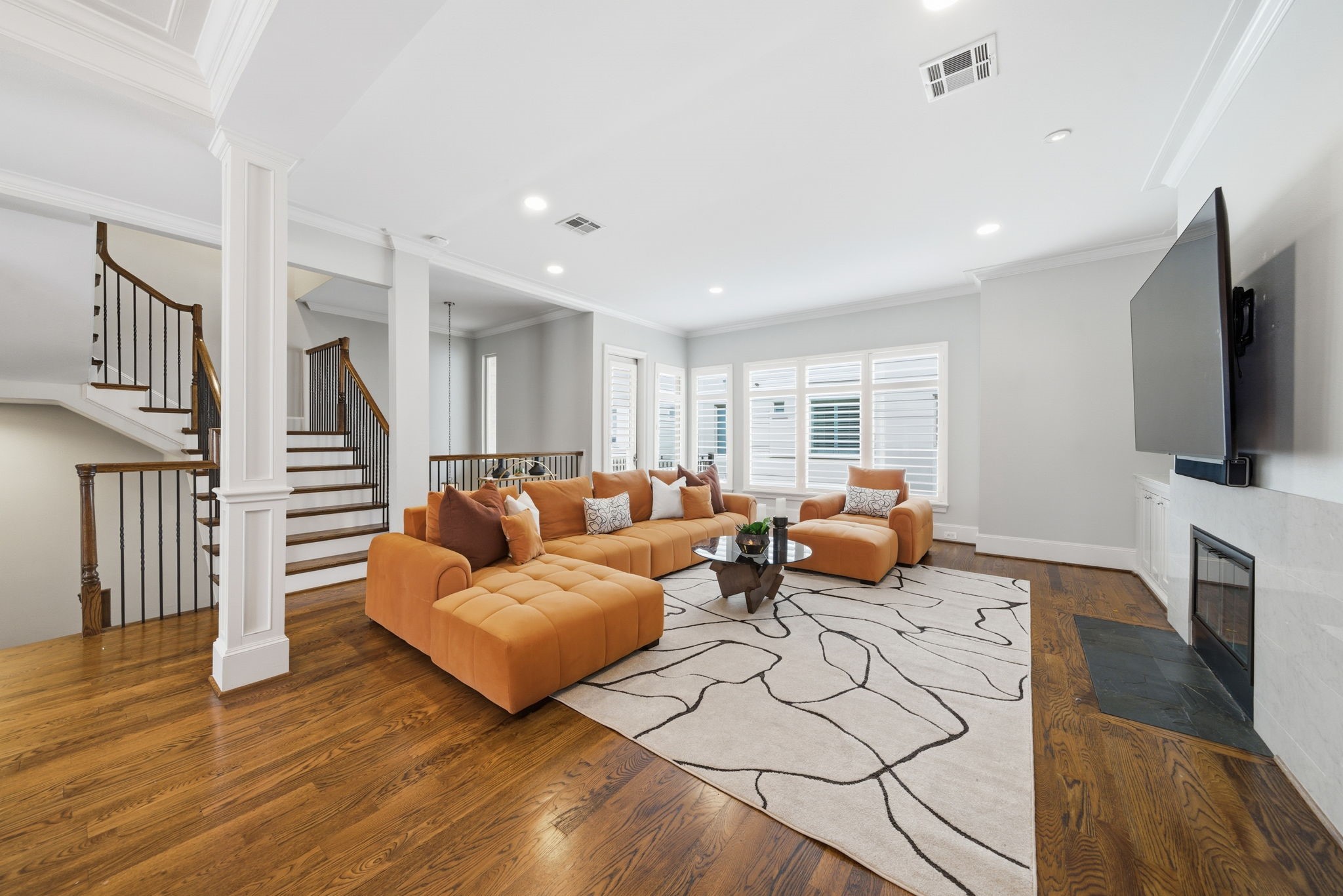 4915 Chenevert Street Houston, TX 77004 - Photo 9 of 41 Sun-filled living area offers an inviting open-concept layout with hardwood flooring and seamless flow to a private balcony. Crisp architectural details, a cozy fireplace, and expansive windows create a warm, contemporary space ideal for relaxing or entertaining in style.