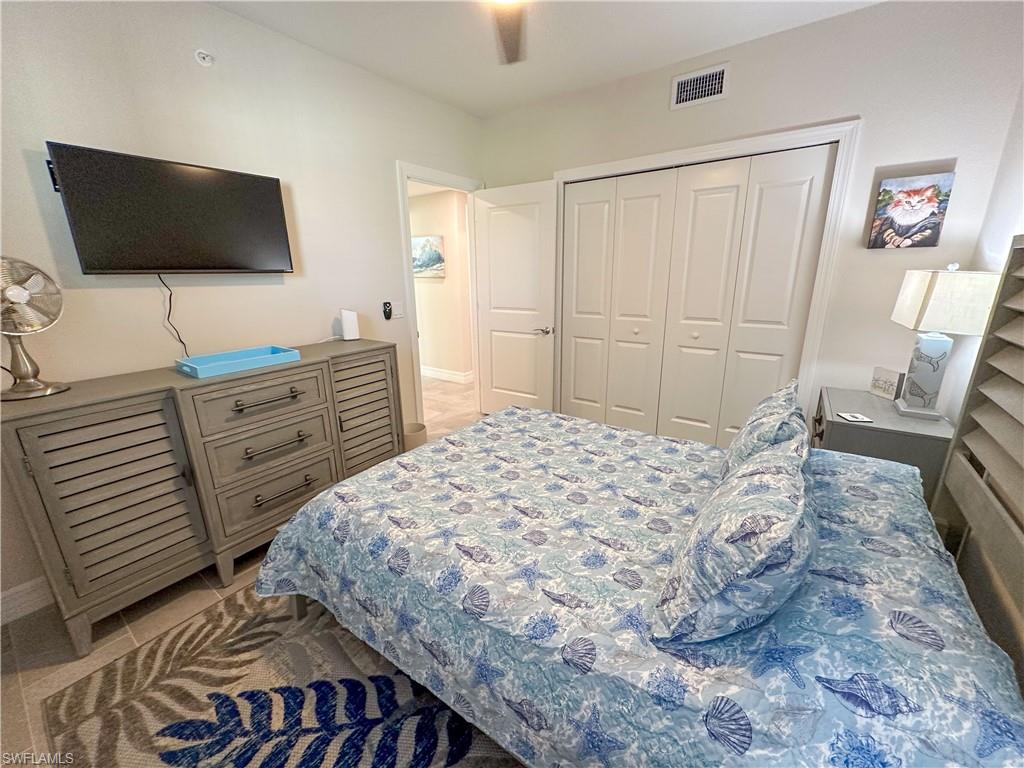 250 Indies Drive East, Unit 101 Naples, FL 34114 - Photo 18 of 49 a bedroom with a bed and a flat screen tv