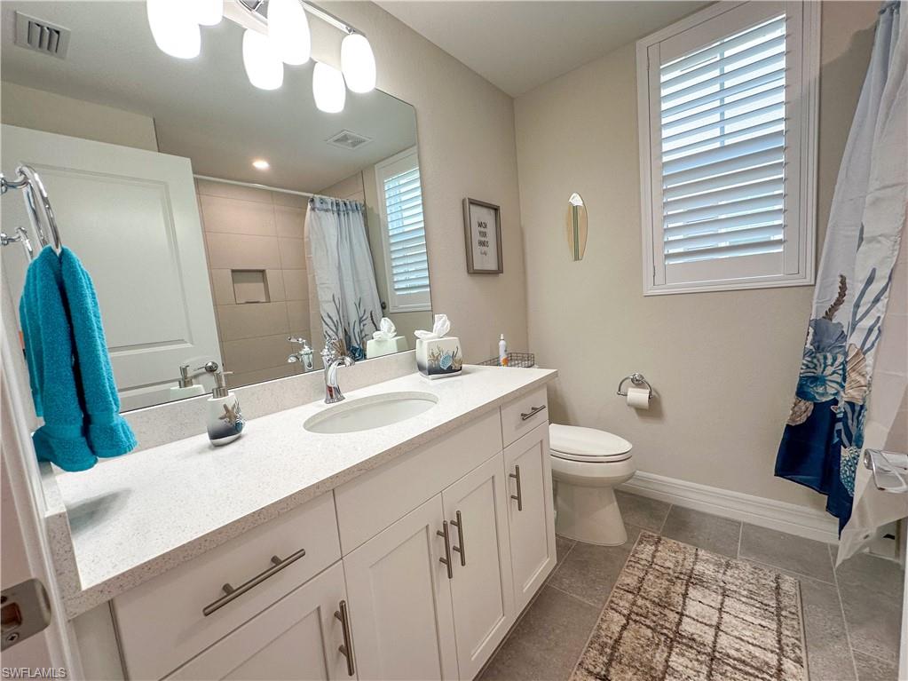 250 Indies Drive East, Unit 101 Naples, FL 34114 - Photo 19 of 49 a bathroom with a double vanity sink and a mirror