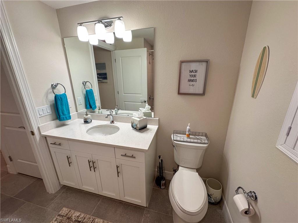 250 Indies Drive East, Unit 101 Naples, FL 34114 - Photo 20 of 49 a bathroom with a toilet a sink and mirror