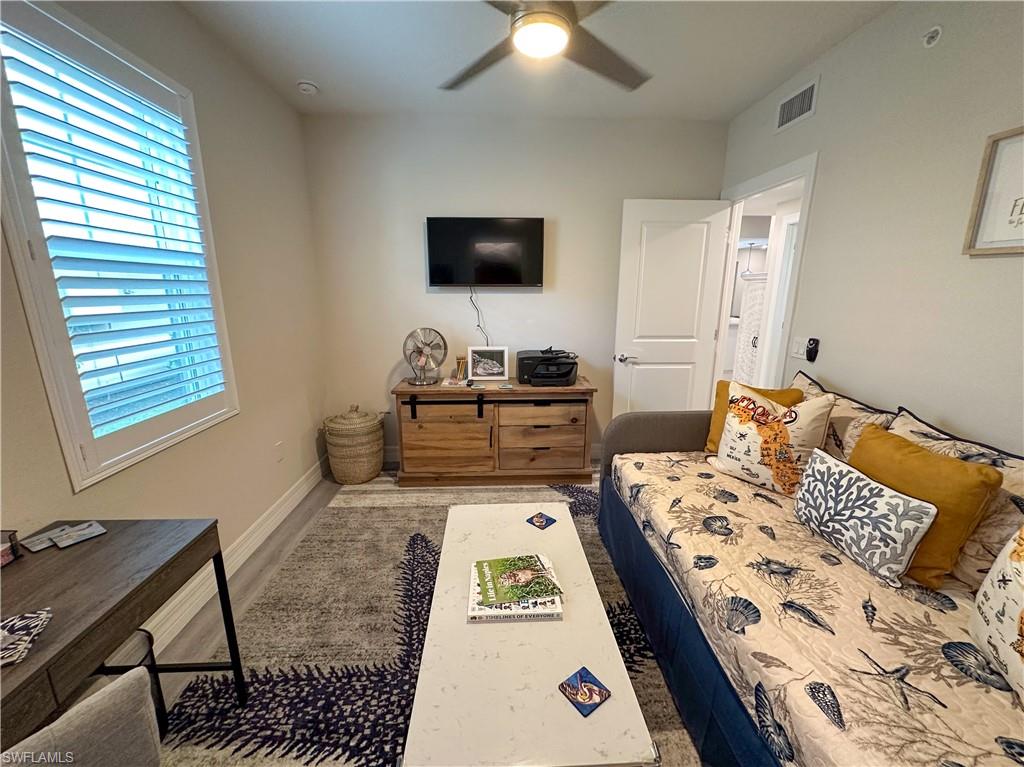 250 Indies Drive East, Unit 101 Naples, FL 34114 - Photo 26 of 49 a bedroom with a bed and a flat screen tv