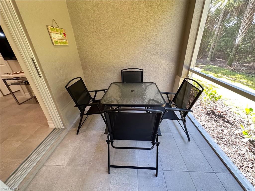 250 Indies Drive East, Unit 101 Naples, FL 34114 - Photo 31 of 49 a living room with a couch and a table