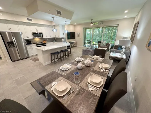 a open dining room with furniture wooden floor and a kitchen view