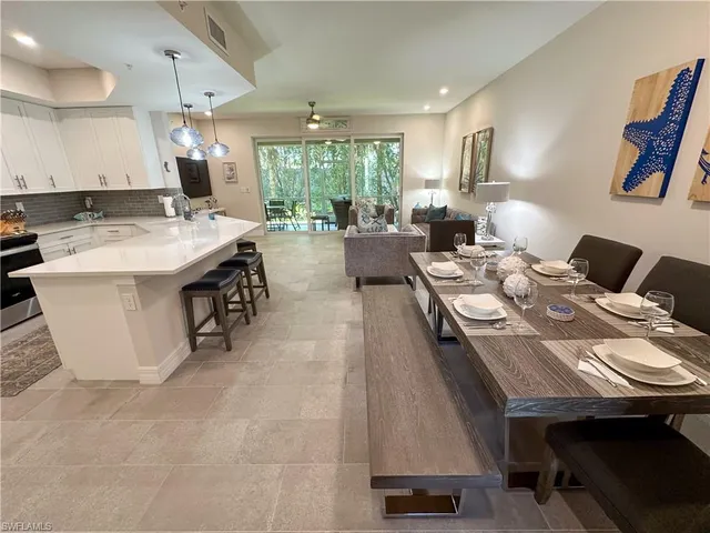 a kitchen with a stove a refrigerator a sink dishwasher with a dining table and chairs