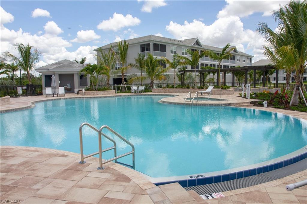 250 Indies Drive East, Unit 101 Naples, FL 34114 - Photo 40 of 49 a view of a swimming pool with chairs