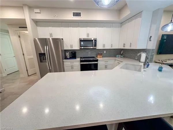 a kitchen with stainless steel appliances a refrigerator sink and microwave