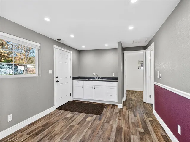 a open kitchen with a sink and dishwasher stove top oven with wooden floor