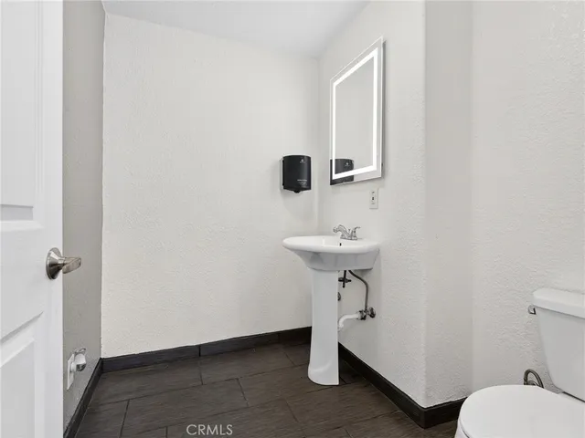 a bathroom with a sink a toilet and mirror