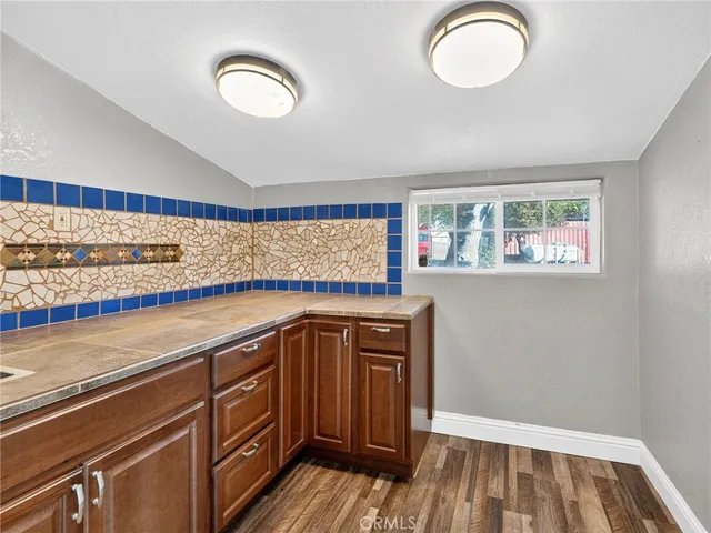 an empty room with wooden floor and window