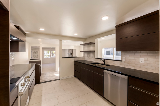 4658 Box Elder Street Salt Lake City, UT 84107 - Photo 11 of 17 Modern kitchen featuring dark wood-finish cabinetry, black countertops, and a subway tile backsplash