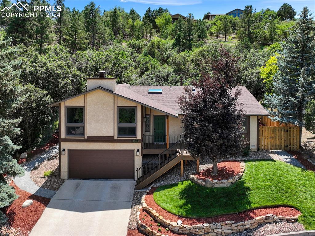 1125 Garlock Lane Colorado Springs, CO 80918 - Photo 1 of 49 a view of a house with a yard fire pit and outdoor seating