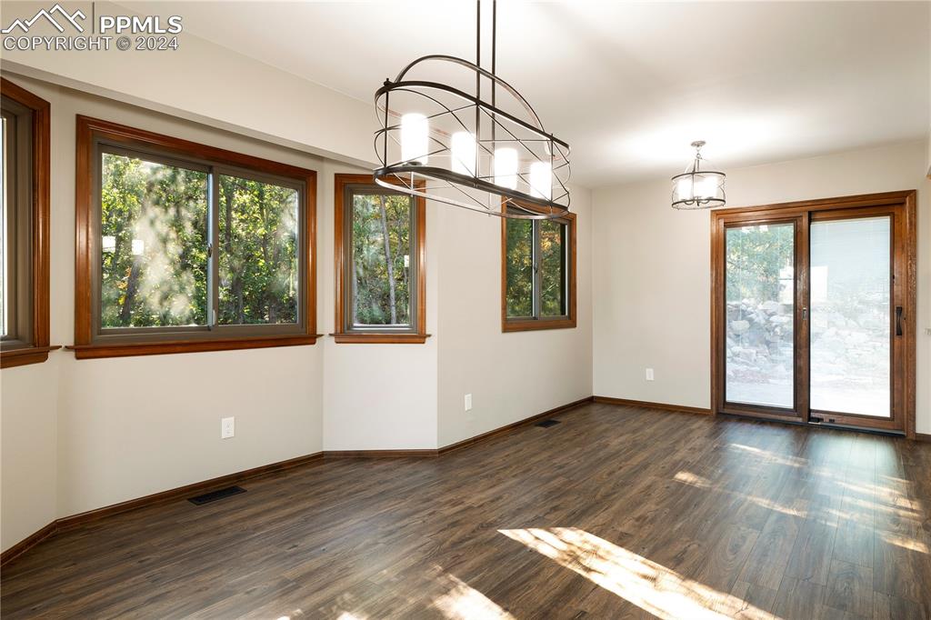 1125 Garlock Lane Colorado Springs, CO 80918 - Photo 11 of 49 a view of an empty room with wooden floor and a window