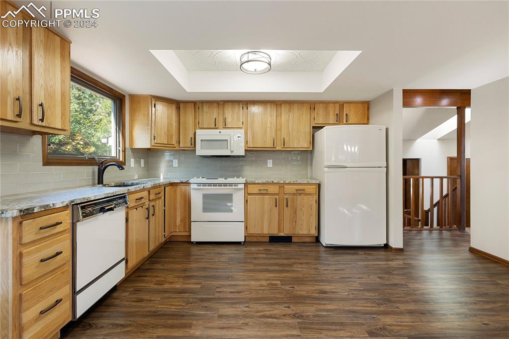 1125 Garlock Lane Colorado Springs, CO 80918 - Photo 14 of 49 a kitchen with a refrigerator a sink and wooden floor