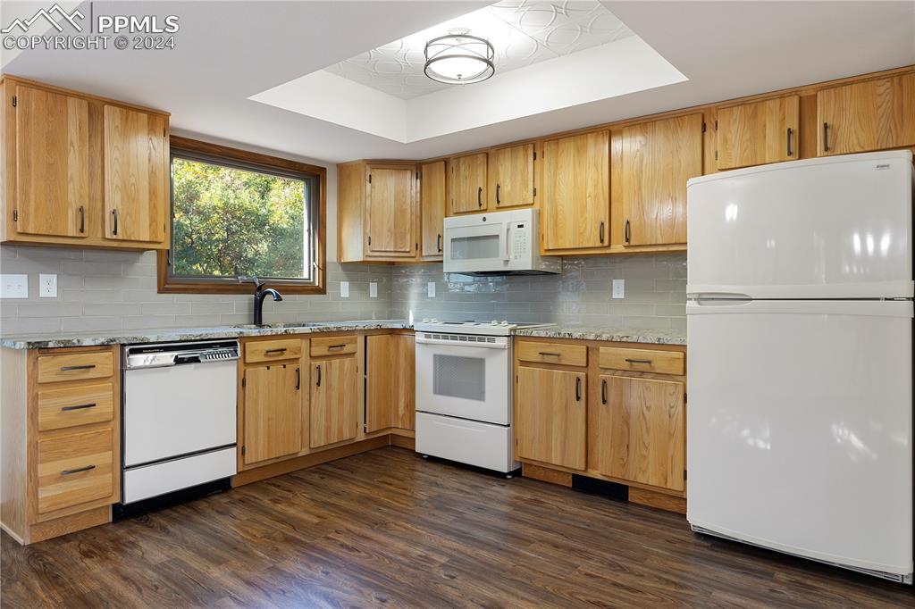 1125 Garlock Lane Colorado Springs, CO 80918 - Photo 15 of 49 a kitchen with a white cabinets and wooden floor