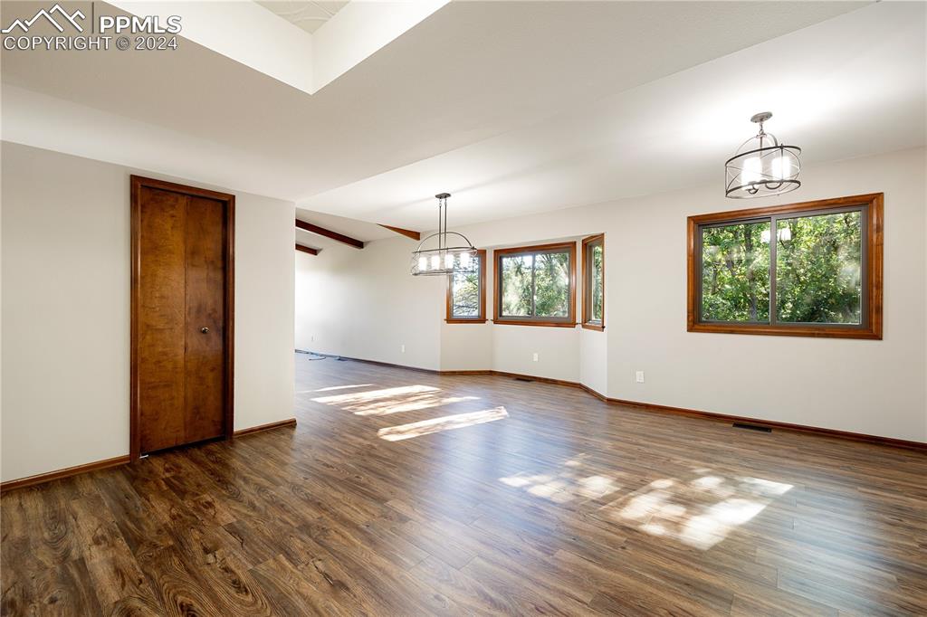 1125 Garlock Lane Colorado Springs, CO 80918 - Photo 17 of 49 an empty room with wooden floor chandelier and windows