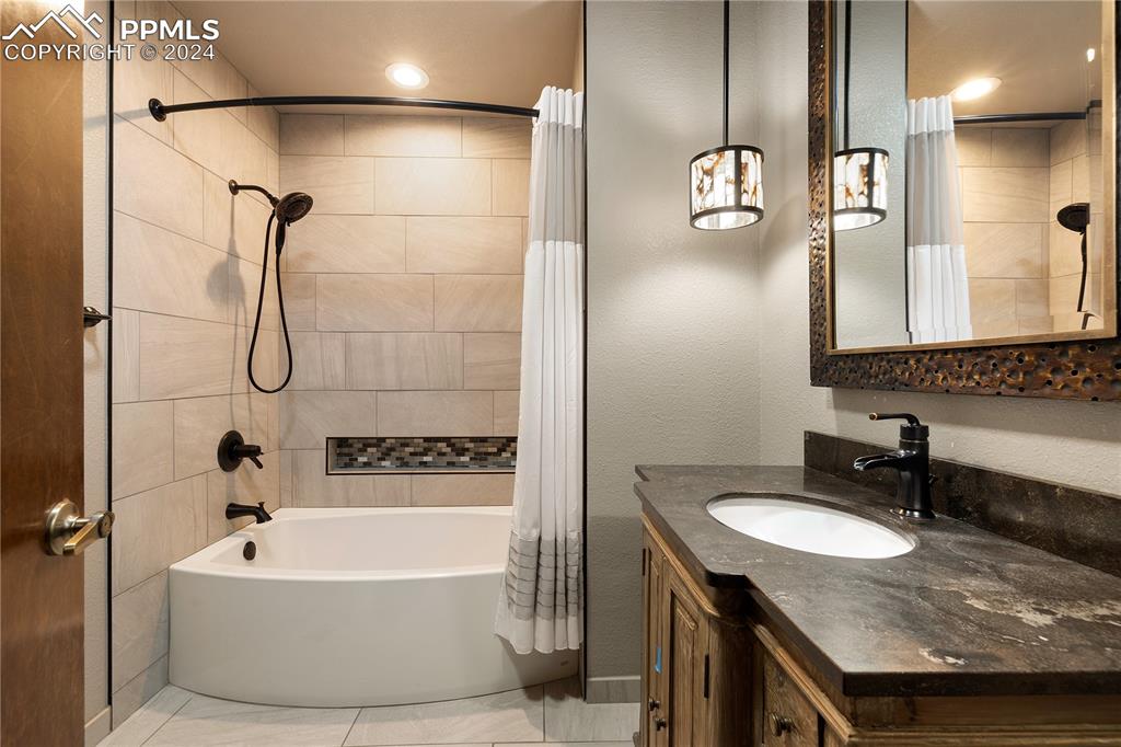 1125 Garlock Lane Colorado Springs, CO 80918 - Photo 35 of 49 a bathroom with a granite countertop sink mirror and a bathtub