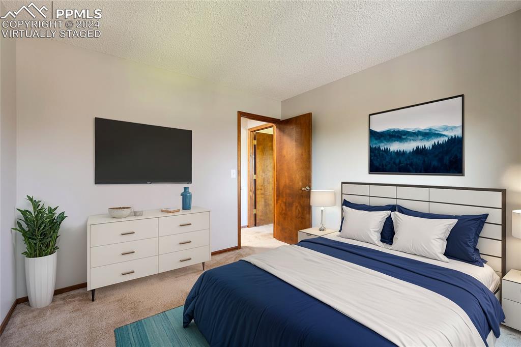 1125 Garlock Lane Colorado Springs, CO 80918 - Photo 36 of 49 a bedroom with a bed and a flat screen tv